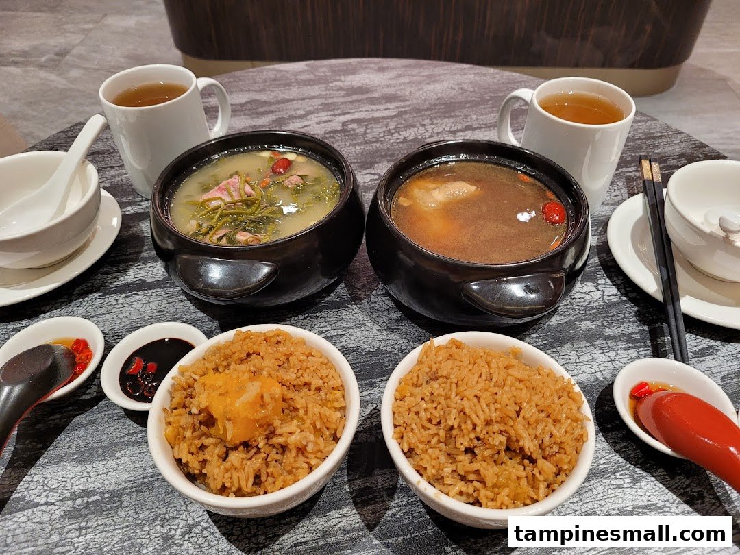 Two traditional Chinese soup bowls with rice and tea served on a table.