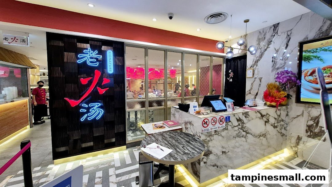 The inviting entrance of Lao Huo Tang Signature, featuring a vibrant neon sign and a glimpse into the dining area.