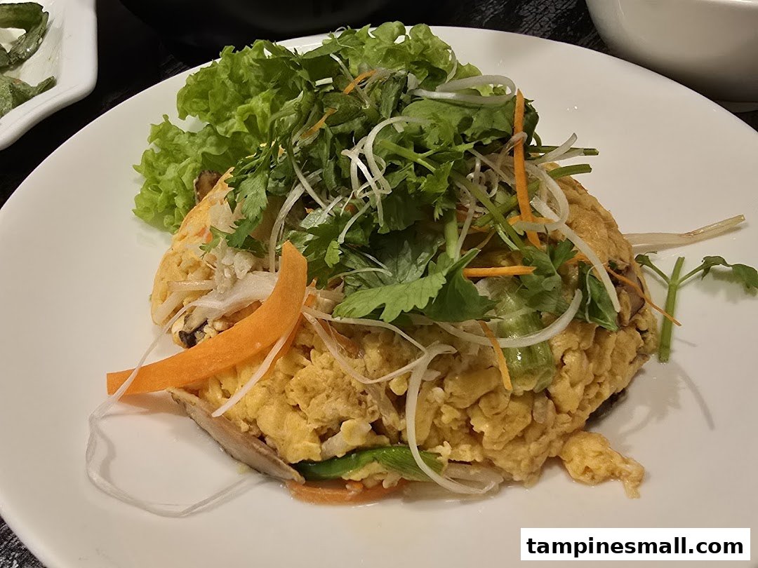 A close-up of a delicious dish featuring scrambled eggs topped with fresh greens and shredded vegetables.