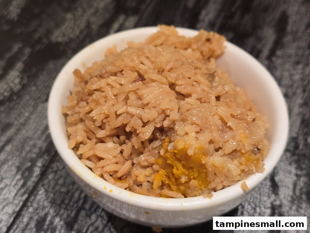 A close-up of a bowl of flavorful rice, possibly pumpkin rice, served at Lao Huo Tang Signature.