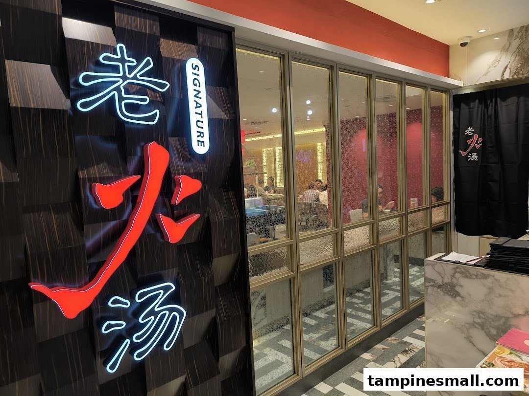 The entrance of Lao Huo Tang Signature with its illuminated logo and a view into the dining area.