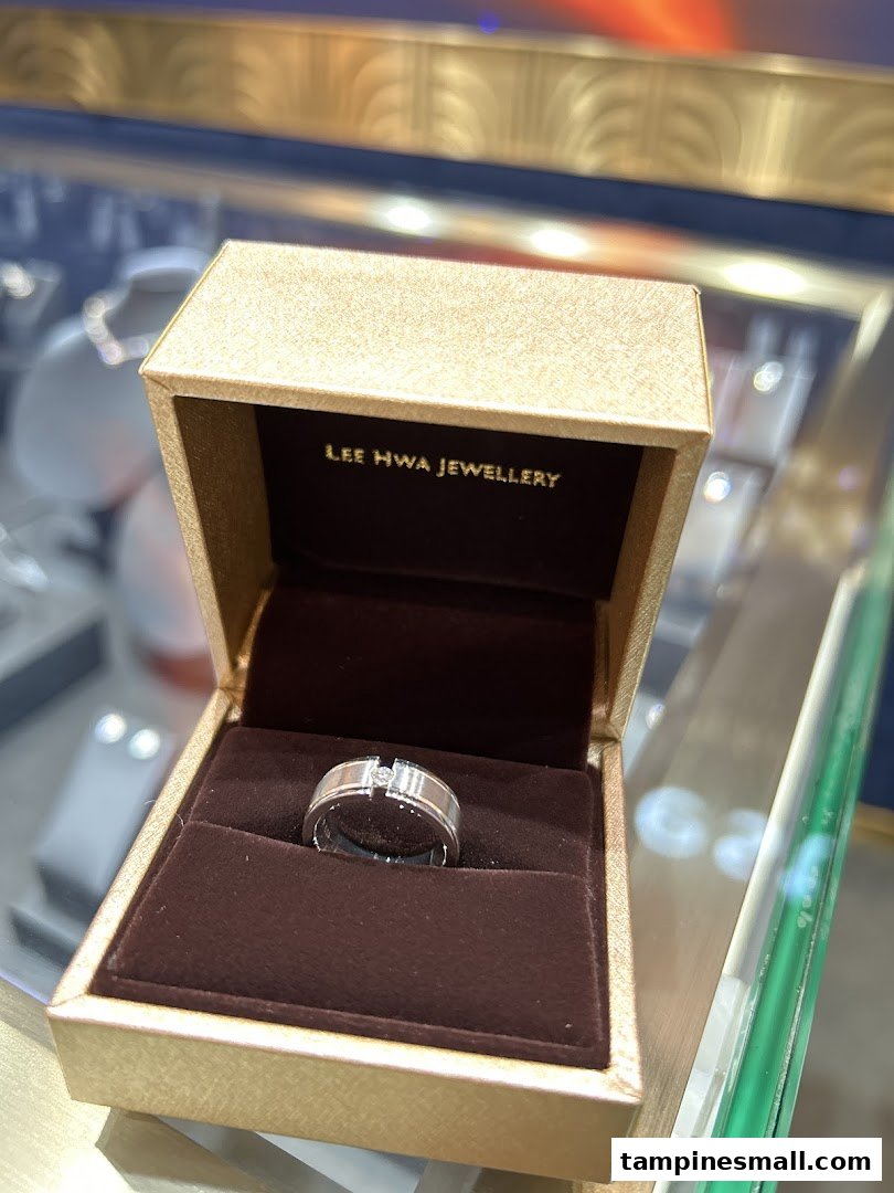 A silver ring with a single diamond set in a Lee Hwa Jewellery branded box.