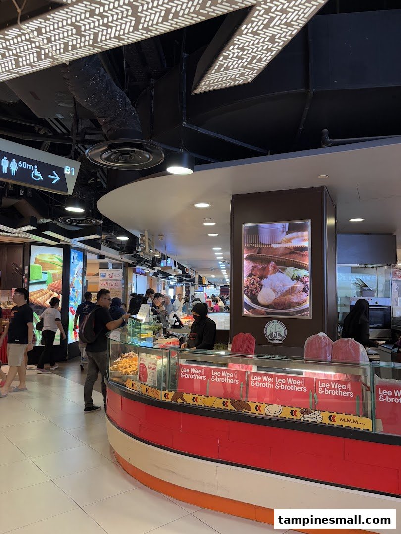 A bustling food stall, Lee Wee Brothers, showcasing its counter with food displays and staff serving customers.