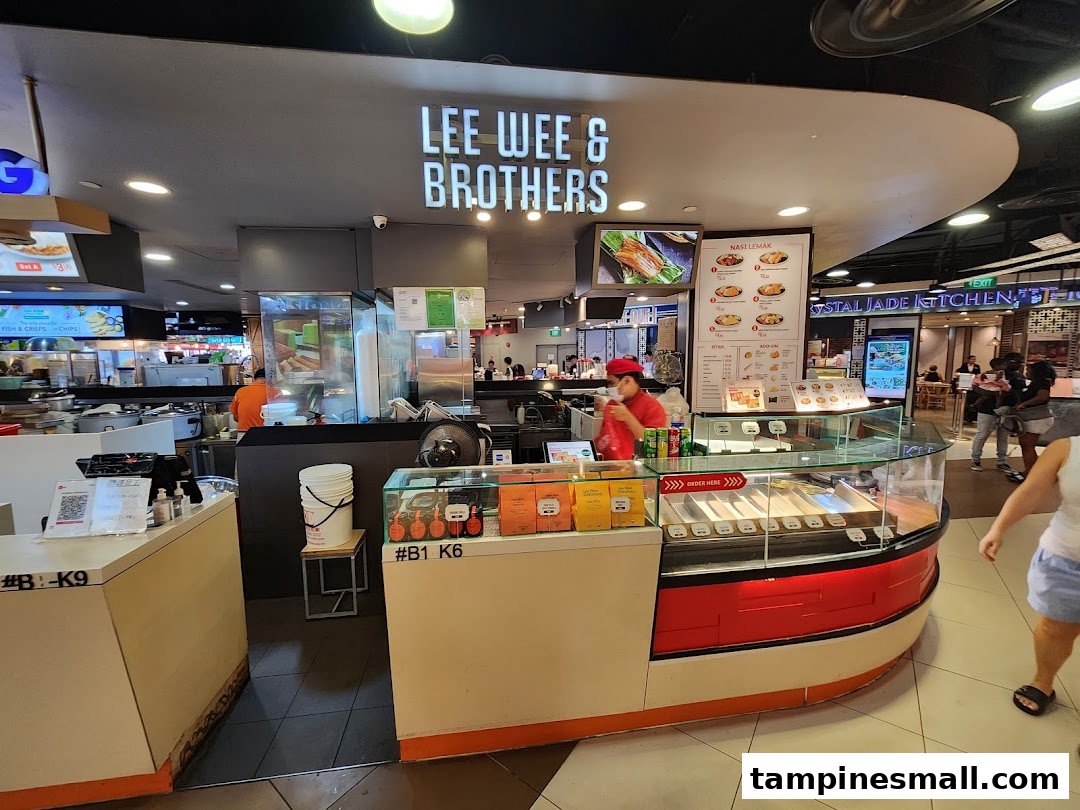 View of Lee Wee Brothers food stall counter with staff, display cases, and menu boards in a food court.