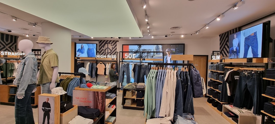 Interior view of a Levi's store showcasing denim, apparel displays, mannequins, and digital screens.