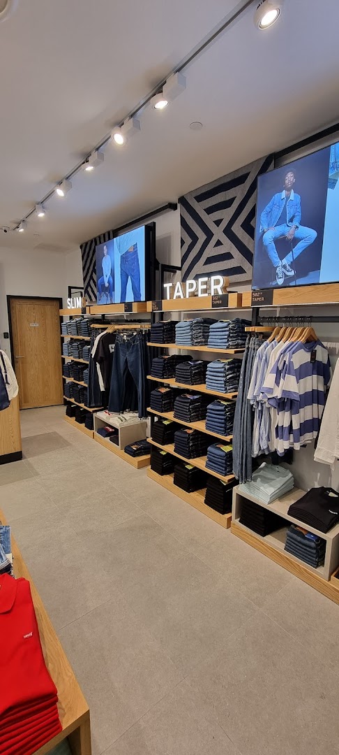 Interior view of a Levi's store showcasing various denim jeans and apparel on display.