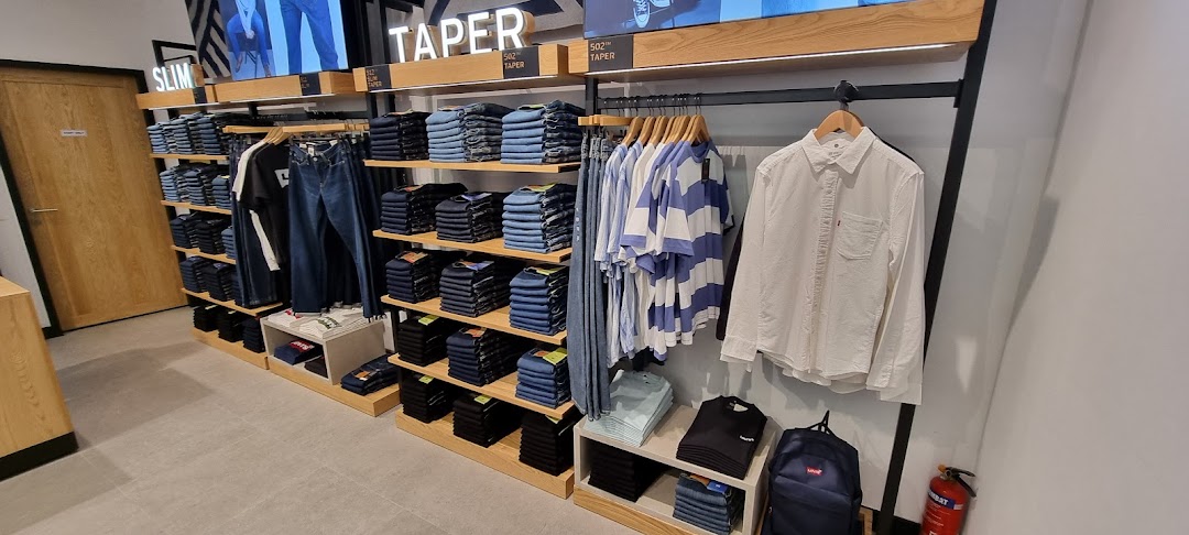 Interior view of a Levi's store showcasing neatly folded jeans, shirts, and accessories on display.