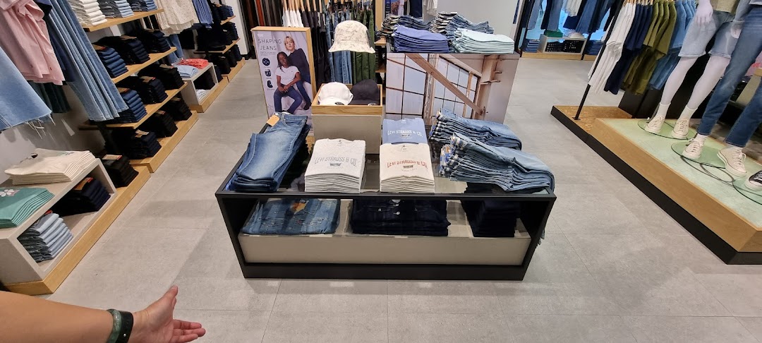 Interior view of a Levi's store showcasing folded jeans, apparel, and display fixtures.
