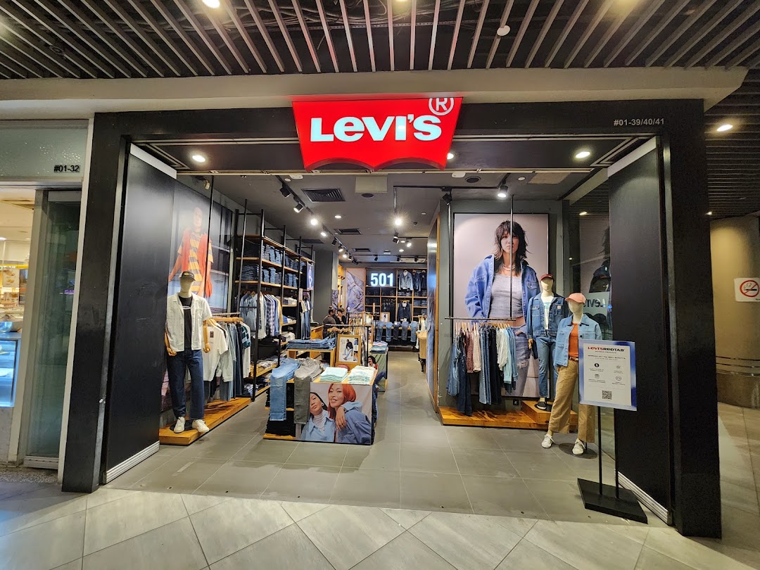 The image displays the well-lit entrance of a Levi's store, showcasing denim apparel and mannequins.
