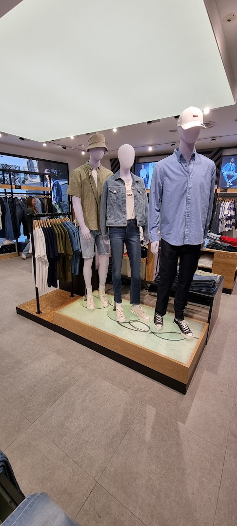 Mannequins display casual denim and apparel inside the Levi's store, showcasing current styles.