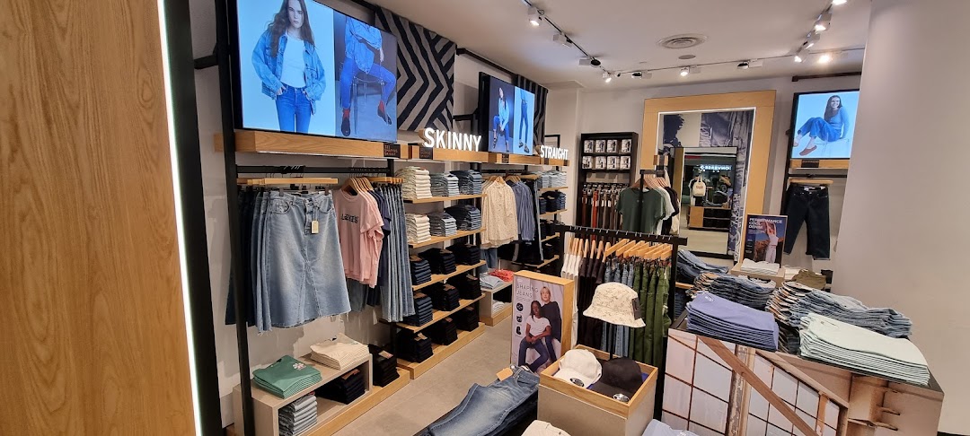 Interior view of a Levi's store showcasing denim apparel, displays, and digital screens.