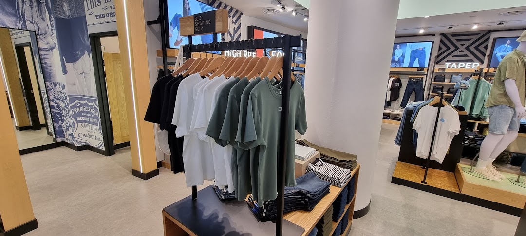 Interior view of Levi's store, showcasing apparel displays, mannequins, and fitting room entrance.