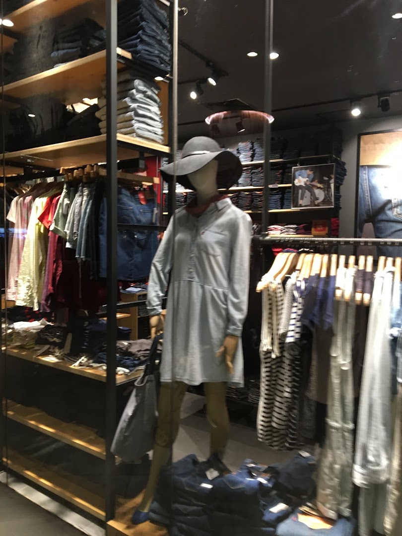 Interior view of a Levi's store, showcasing clothing racks, folded denim, and a mannequin.