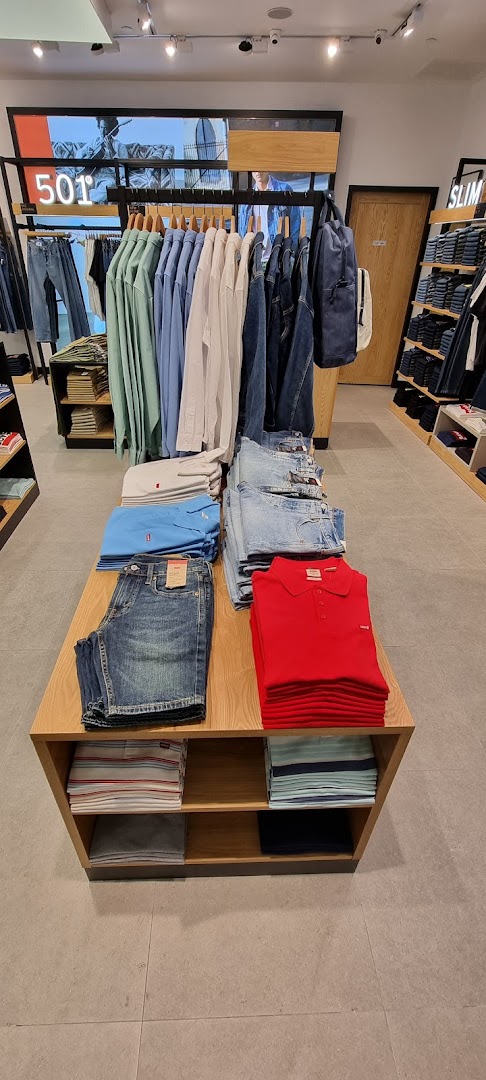 Interior view of a Levi's store showcasing denim, shirts, and apparel on display tables and racks.