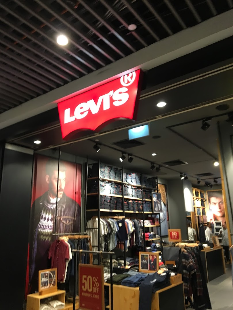 The image displays the vibrant red Levi's logo above the entrance of a well-stocked denim and apparel store.