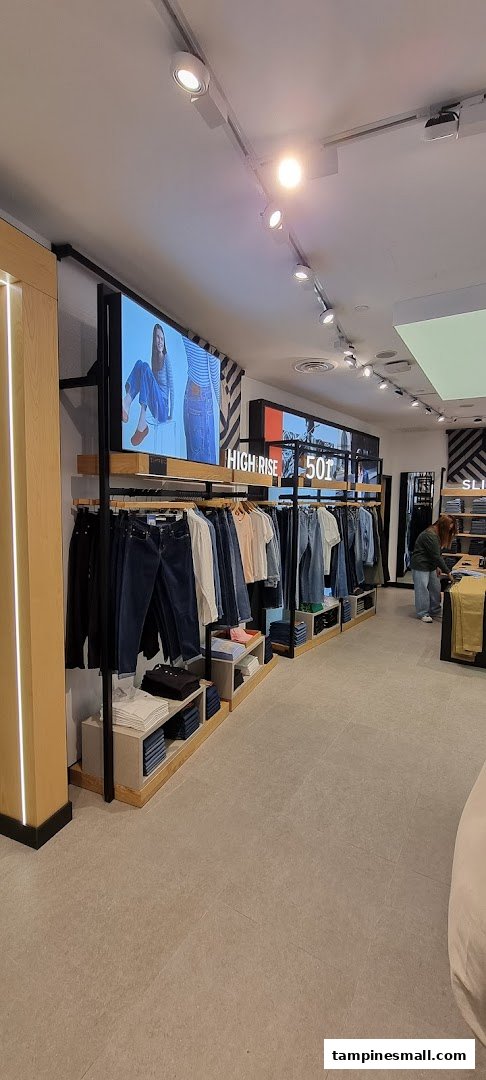 Interior view of a Levi's store, showcasing denim apparel, digital displays, and a customer browsing.