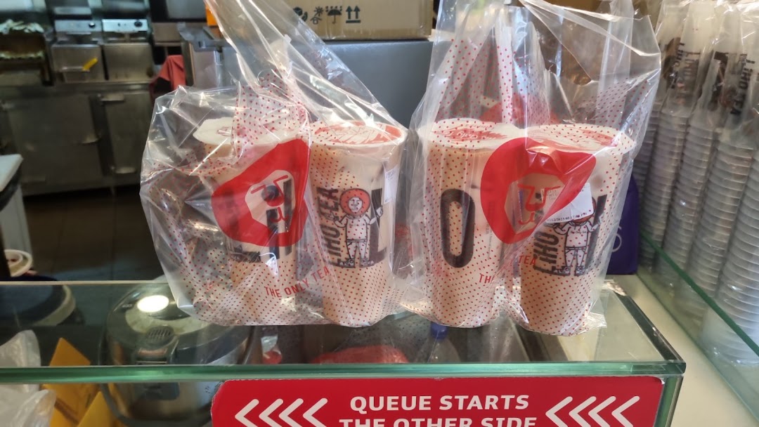Several LiHO TEA bubble tea drinks, packaged in clear bags, ready for pickup at the counter.