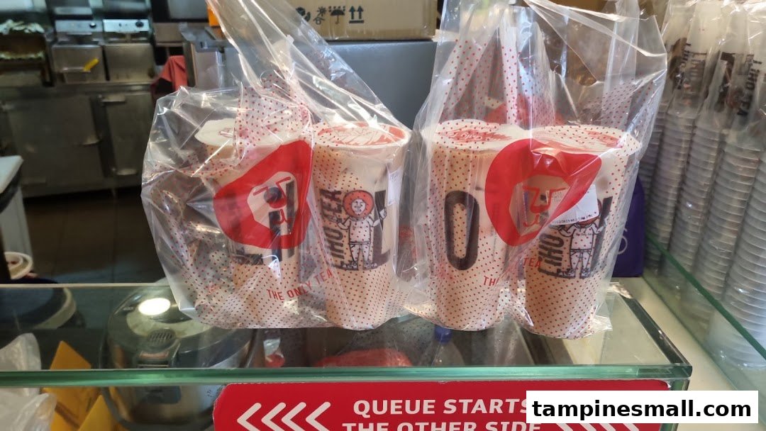 Several LiHO TEA bubble tea drinks, packaged in clear bags, ready for pickup at the counter.