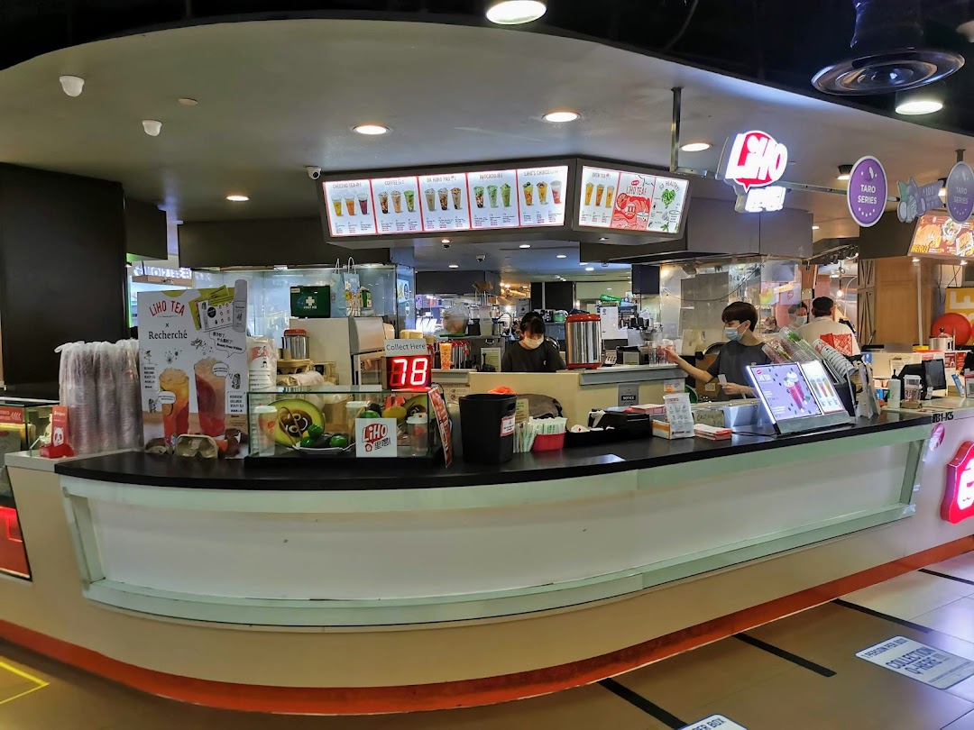 LiHO TEA counter with staff preparing drinks and various promotional displays.