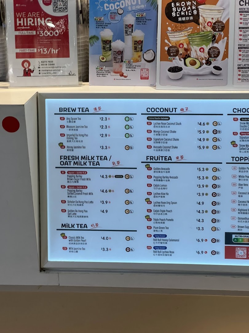 A brightly lit menu board displaying various tea and fruit beverages with prices at LiHO TEA.
