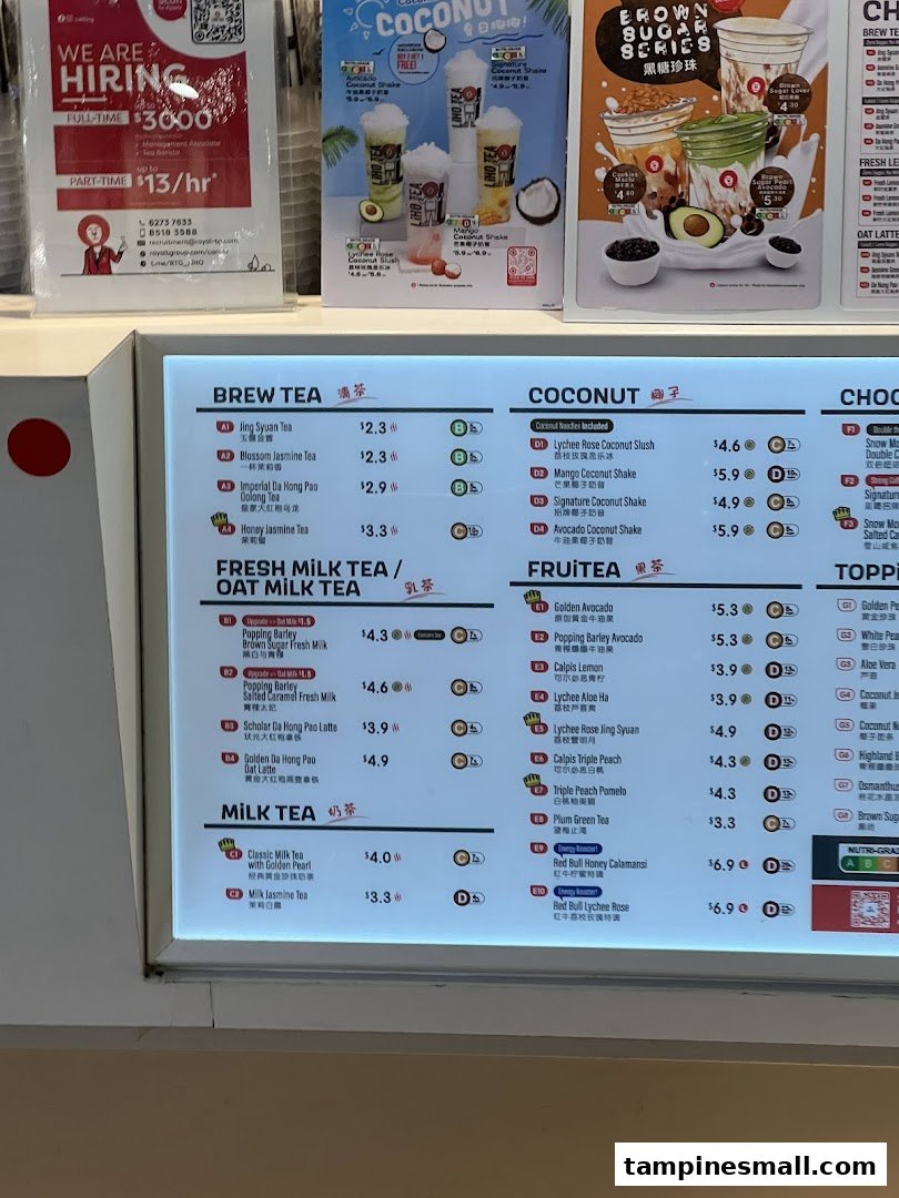 A brightly lit menu board displaying various tea and fruit beverages with prices at LiHO TEA.