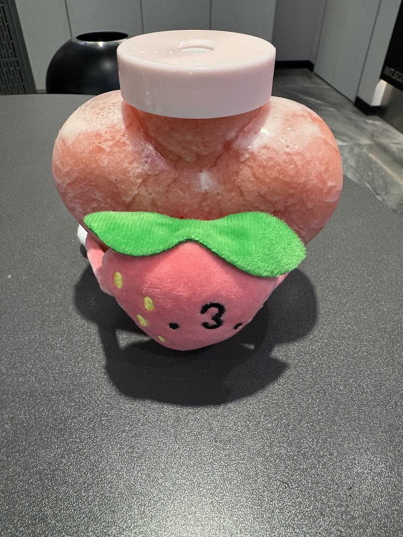 A heart-shaped frozen drink with a cute strawberry plushie, likely from LiHO TEA.