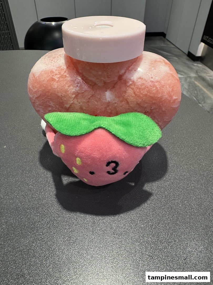 A heart-shaped frozen drink with a cute strawberry plushie, likely from LiHO TEA.