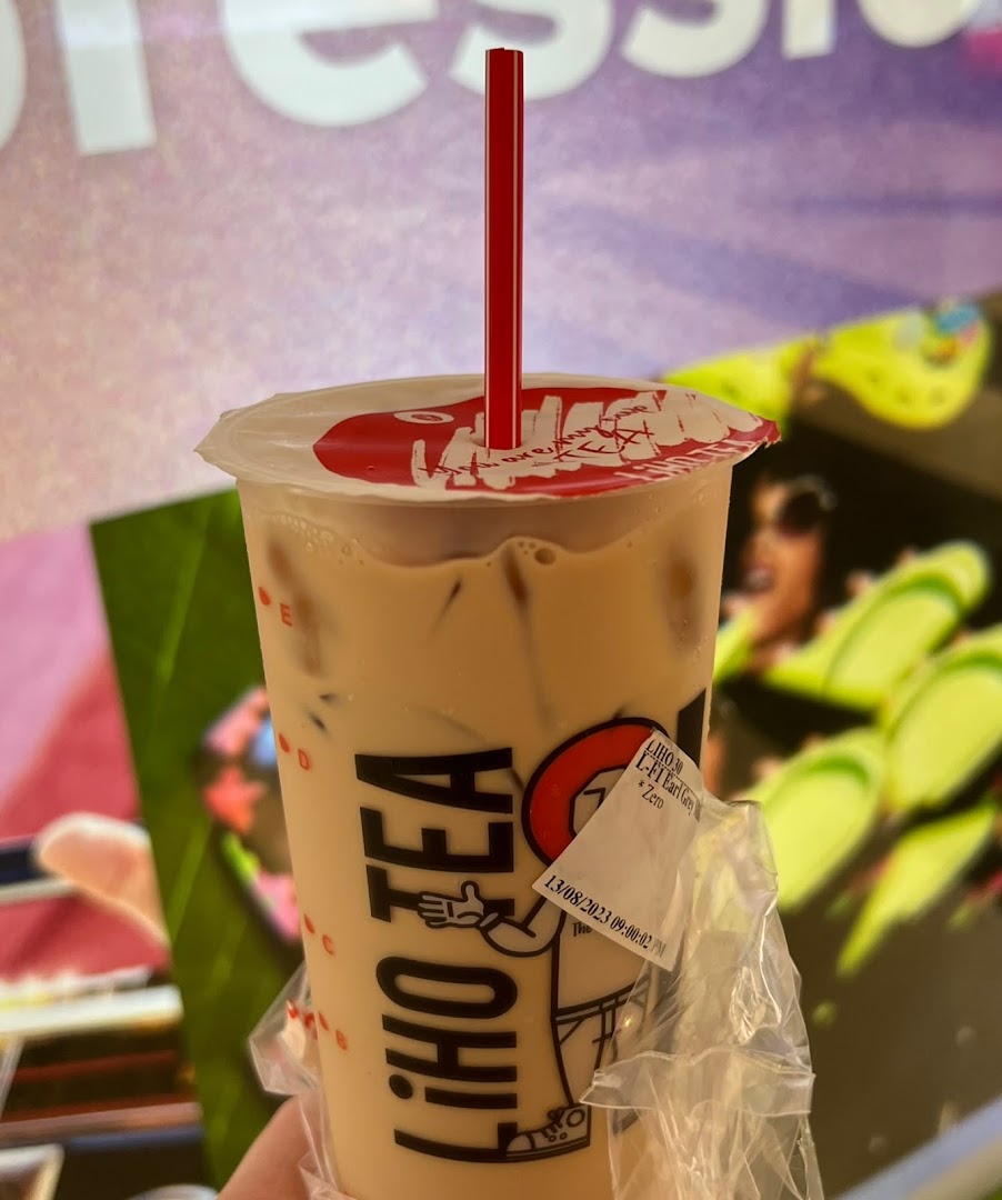 A close-up of a refreshing LiHO TEA Earl Grey milk tea with a red straw.