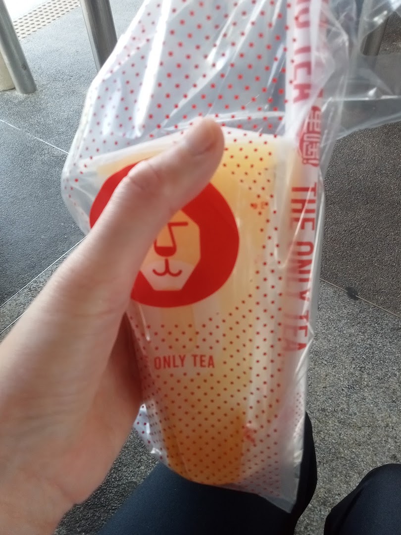 A hand holds a refreshing LiHO TEA drink in a branded cup and carrier bag.