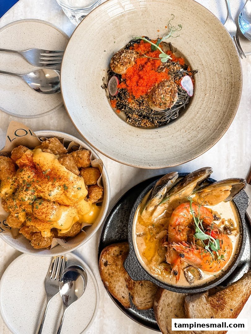 An overhead view of three delicious dishes: black pasta with scallops, cheesy tots, and a seafood stew.