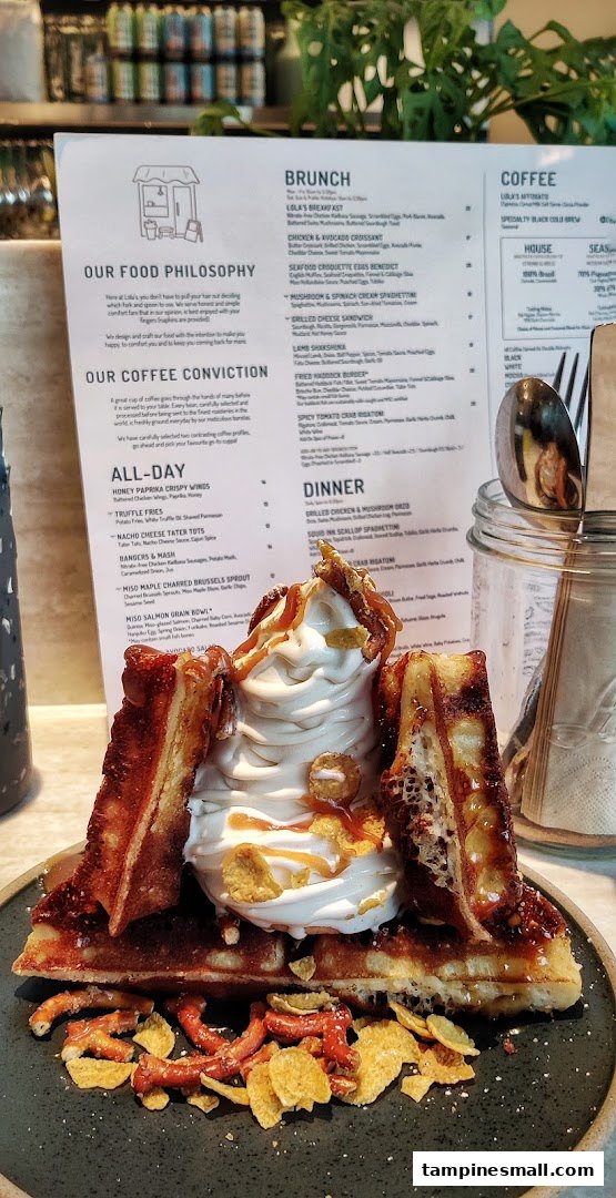 A delicious waffle dessert with ice cream and toppings, with a detailed menu from Lola's in the background.
