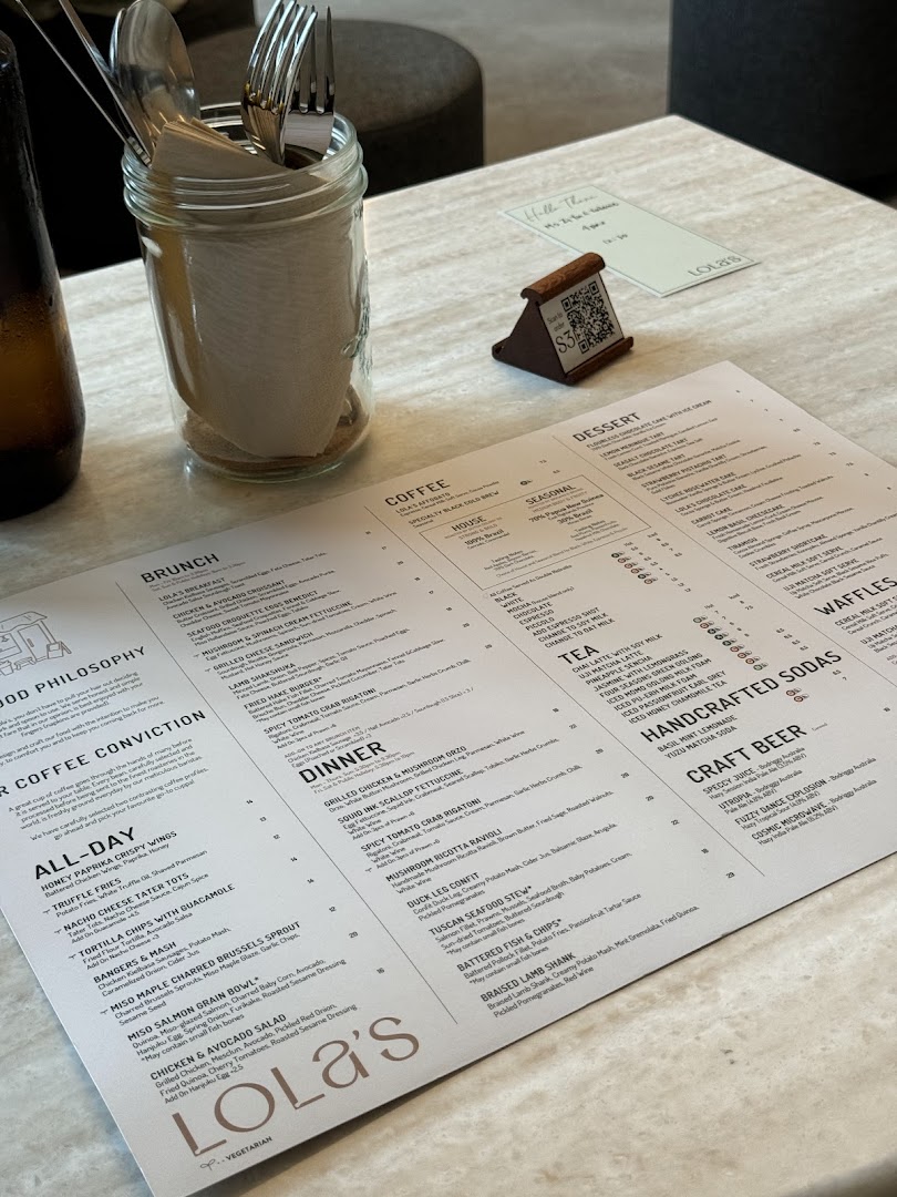 A detailed menu from Lola's cafe, featuring a variety of food and drink options, displayed on a table.