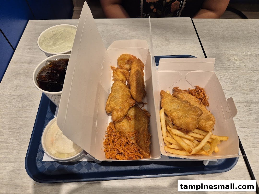A tray with two boxes of Long John Silver's fried fish and shrimp, fries, drinks, and coleslaw.
