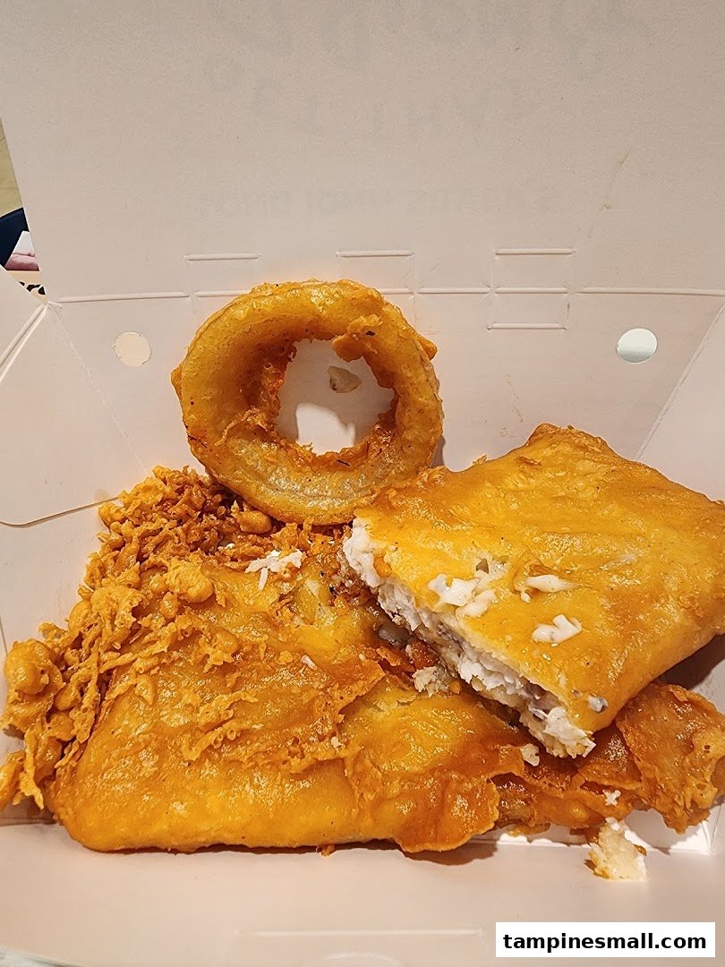 Golden-fried fish and crispy onion rings served in a takeout box from Long John Silver's.