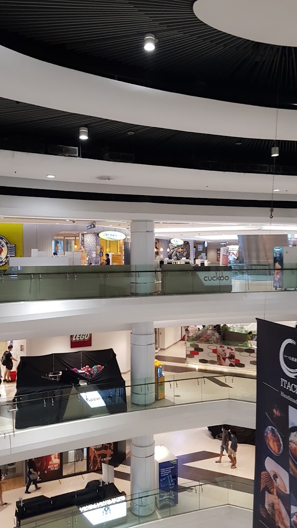 A multi-level view of a bustling shopping mall interior showcasing various retail and dining establishments.