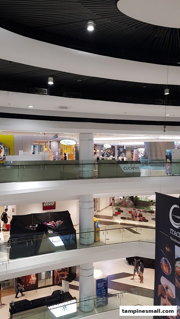 A multi-level view of a bustling shopping mall interior showcasing various retail and dining establishments.