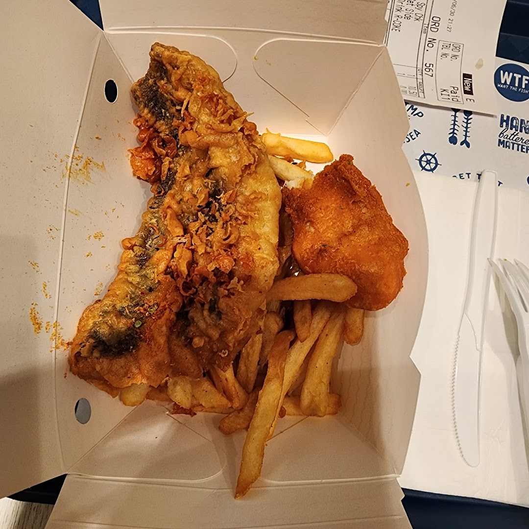 A close-up of crispy battered fish and golden fries in a takeaway box from Long John Silver's.
