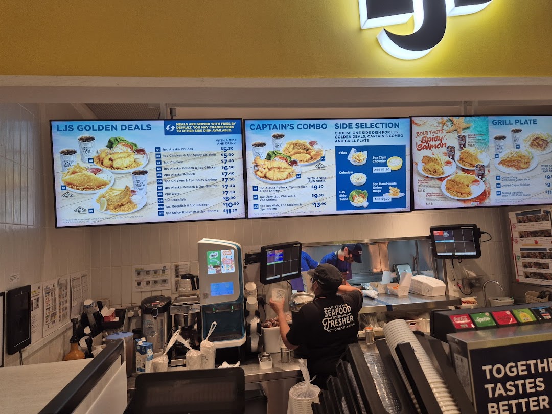 Digital menu boards display seafood and chicken meals at Long John Silver's counter.