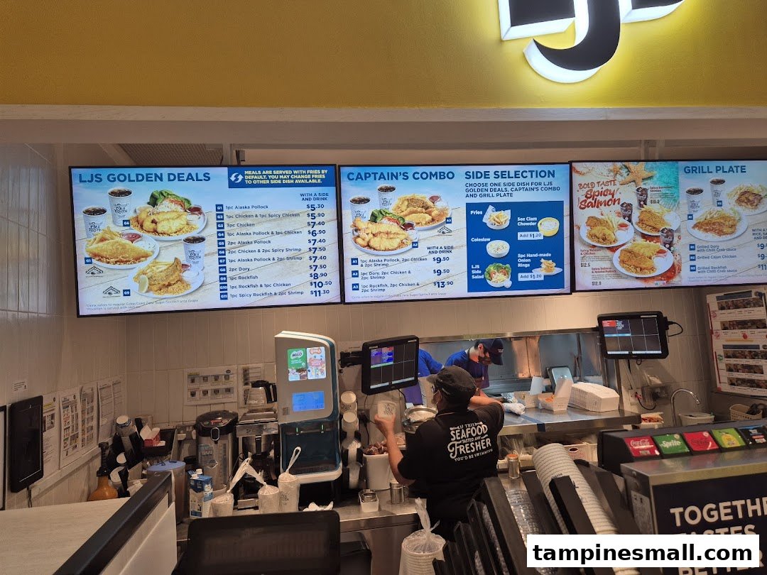 Digital menu boards display seafood and chicken meals at Long John Silver's counter.