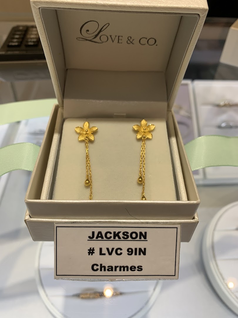 Close-up of gold floral drop earrings displayed in a white box from Love & Co.