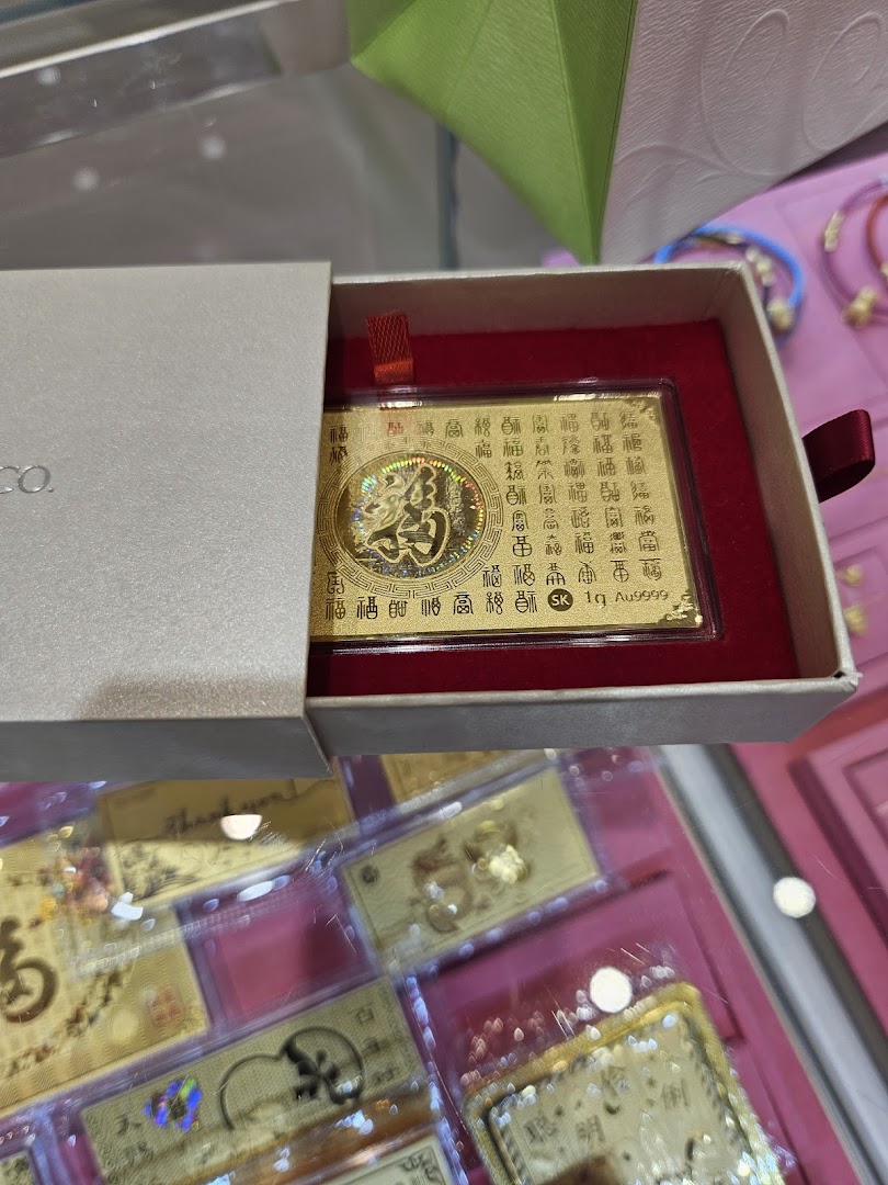 A close-up of a decorative gold bar with Chinese characters in a gift box, displayed in a retail setting.