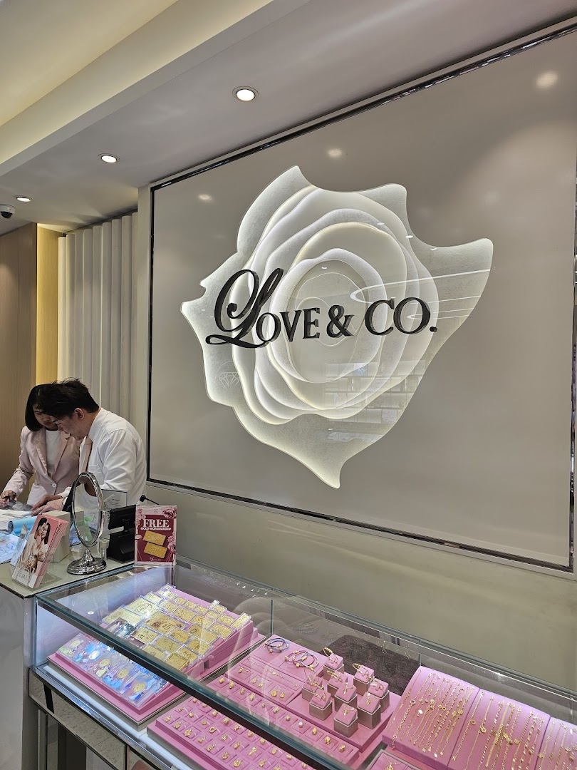 Interior view of Love & Co. jewelry store, showcasing display cases with gold and diamond pieces, and staff assisting customers.