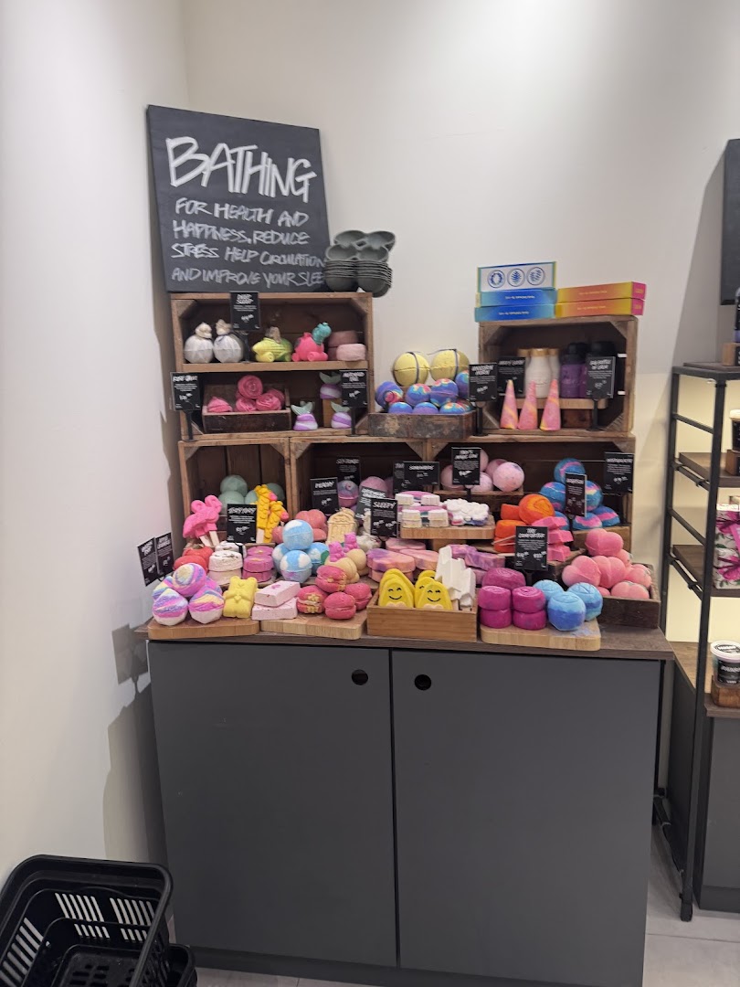 A vibrant display of Lush's handmade bath and body products, including colorful bath bombs and soaps.