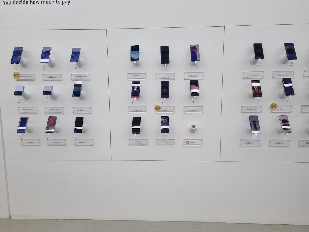 A clean display wall showcasing a wide range of modern smartphones in a retail store.