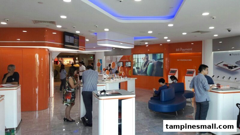 Customers browse phones and interact with staff in a modern, orange-themed phone and internet service shop.
