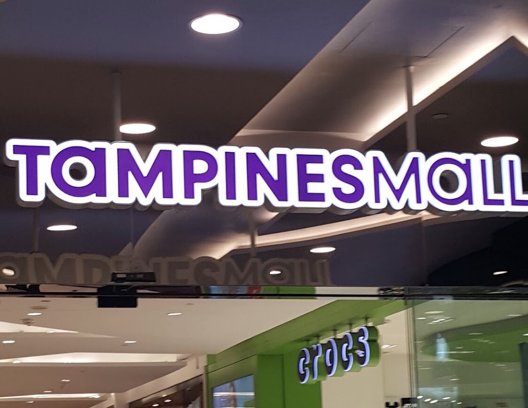 Illuminated 'TAMPINESMALL' sign and a 'CROCS' store sign visible inside the mall.