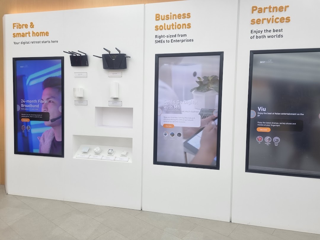 A retail display showcasing M1's fibre broadband, smart home devices, business solutions, and partner services.