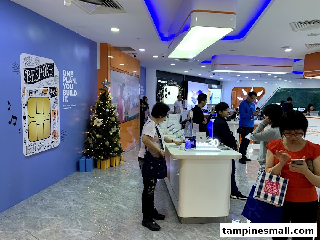 Customers browse smartphones and internet services in a modern, brightly lit M1 store with festive decorations.
