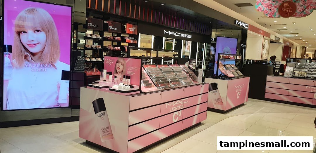 Interior view of MAC Cosmetics store with product displays, makeup studio, and a large digital screen.
