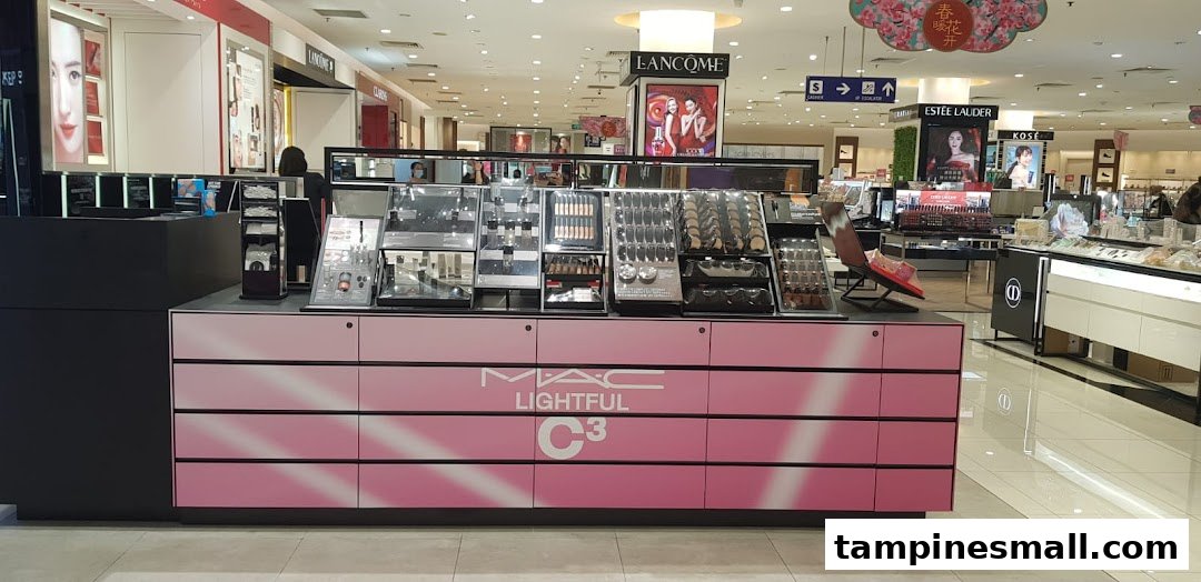 A MAC Cosmetics counter featuring makeup displays and products, located within a brightly lit department store.